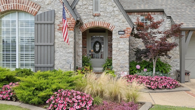 5117 E 92nd St, Tulsa, OK 74137 - doorway to property featuring stone siding and a shingled roof
