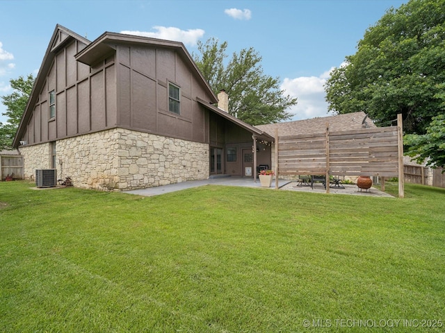 5607 E 76th St, Tulsa, OK 74136 - back of house with a patio area, stone siding, a chimney, and board and batten siding