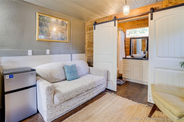 62141 E 313th Rd Unit 3, Grove, OK 74344 - sitting room featuring dark wood-style flooring, a barn door, wood walls, wood ceiling, and a textured wall