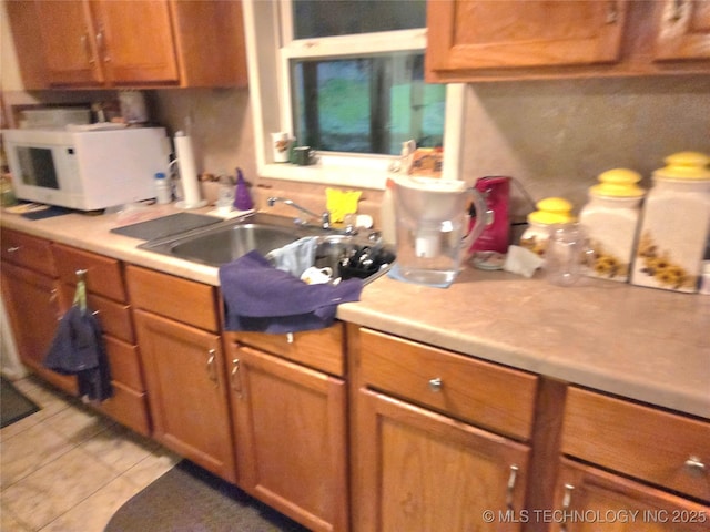 92133 S 4676th Rd, Bunch, OK 74931 - kitchen with white microwave, light countertops, and brown cabinetry