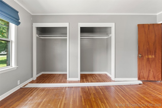 17997 S 4160th Rd W, Claremore, OK 74017 - unfurnished bedroom with multiple closets, multiple windows, wood finished floors, and crown molding