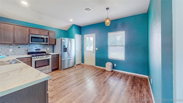 15081 S 276th E Ave, Broken Arrow, OK 74429 - kitchen with stainless steel appliances, tasteful backsplash, light wood finished floors, light countertops, and hanging light fixtures