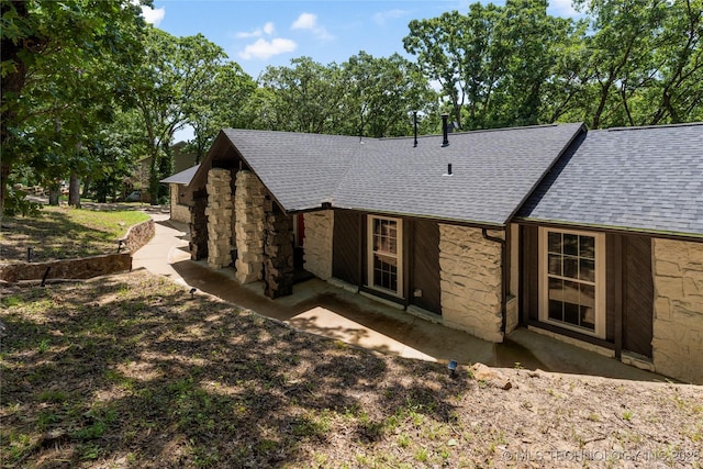 29012 E 63rd St, Broken Arrow, OK 74014 - view of side of property with stone siding, roof with shingles, and a patio