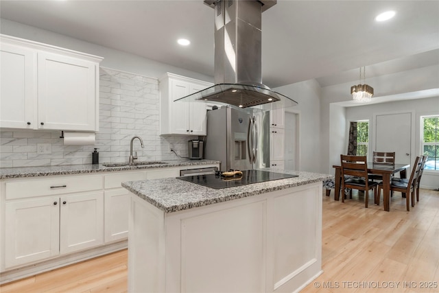 29012 E 63rd St, Broken Arrow, OK 74014 - kitchen featuring island exhaust hood, stainless steel fridge, black electric stovetop, backsplash, and white cabinets