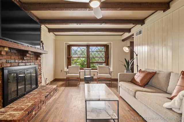 5225 S Toledo Ave, Tulsa, OK 74135 - living room with a brick fireplace, beam ceiling, hardwood / wood-style floors, a ceiling fan, and wood walls