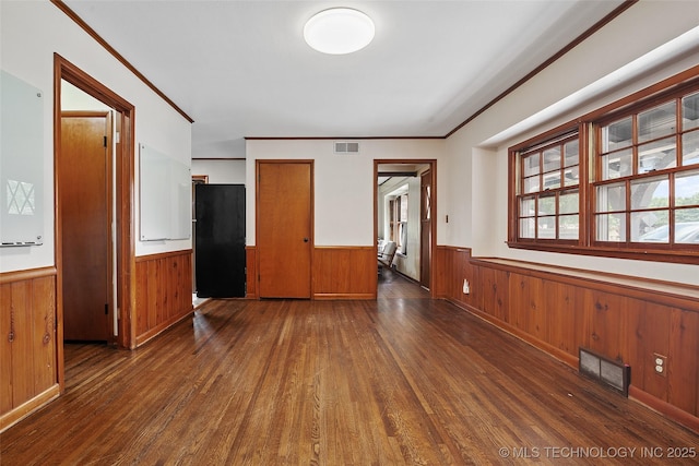 5225 S Toledo Ave, Tulsa, OK 74135 - spare room featuring wainscoting, wood finished floors, wooden walls, and ornamental molding