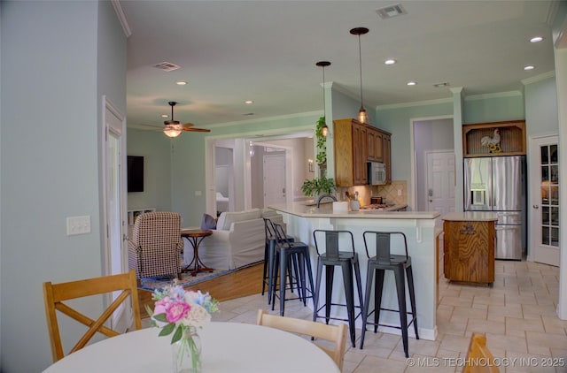 14230 S Urbana Ave, Bixby, OK 74008 - kitchen featuring stainless steel appliances, ornamental molding, backsplash, a peninsula, and ceiling fan