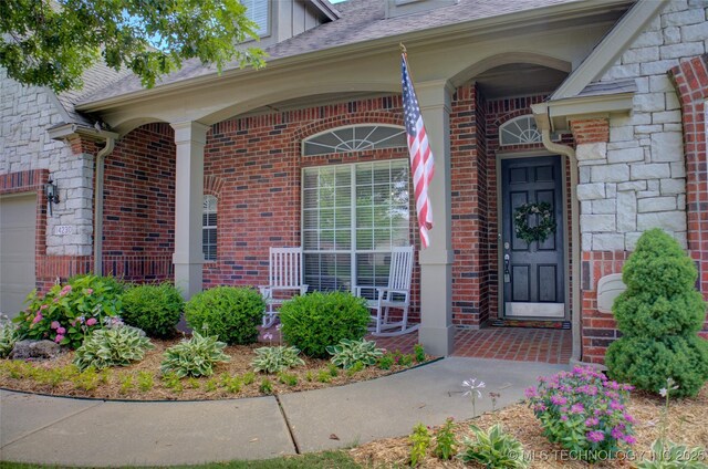 14230 S Urbana Ave, Bixby, OK 74008 - property entrance with a porch, brick siding, and stone siding