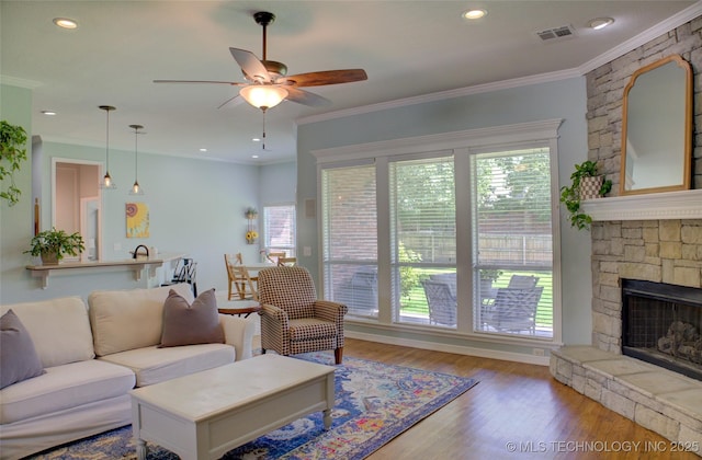 14230 S Urbana Ave, Bixby, OK 74008 - living room with ceiling fan, wood finished floors, crown molding, a stone fireplace, and recessed lighting
