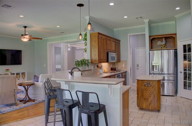 14230 S Urbana Ave, Bixby, OK 74008 - kitchen with stainless steel appliances, a center island, a peninsula, decorative backsplash, and light countertops