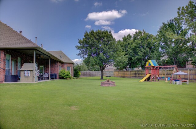 14230 S Urbana Ave, Bixby, OK 74008 - fenced backyard featuring a playground, an outdoor fire pit, ceiling fan, and a patio