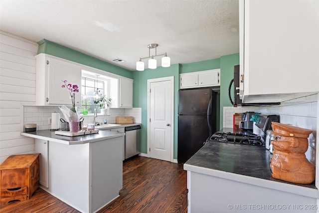19935 Mountain Ln, Claremore, OK 74019 - kitchen featuring black appliances, a peninsula, dark wood-style floors, decorative backsplash, and a textured ceiling