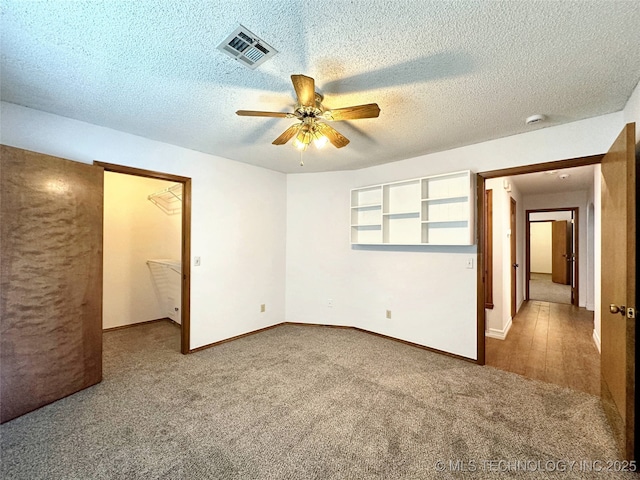6223 S Cedar Pl, Broken Arrow, OK 74011 - unfurnished bedroom with carpet, a textured ceiling, a spacious closet, and ceiling fan
