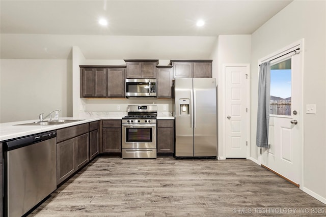 23561 E 114th Ct, Broken Arrow, OK 74014 - kitchen with appliances with stainless steel finishes, light wood-style flooring, dark brown cabinetry, light countertops, and recessed lighting