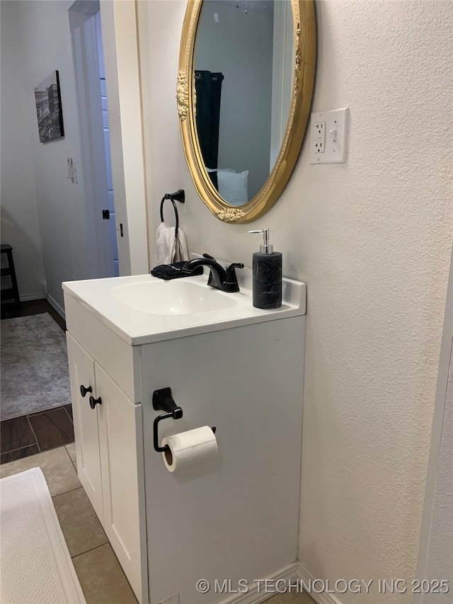321 E 10th St, Pawhuska, OK 74056 - bathroom with vanity, a textured wall, and wood finished floors