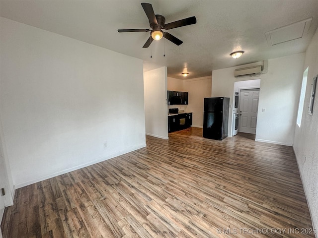 916 Coy Ave, Tahlequah, OK 74464 - unfurnished living room with a wall unit AC, wood finished floors, a ceiling fan, and attic access