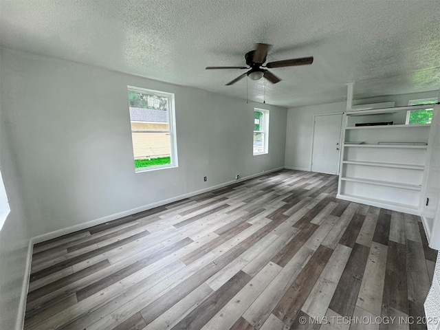 916 Coy Ave, Tahlequah, OK 74464 - unfurnished living room featuring a textured ceiling, wood finished floors, and a ceiling fan