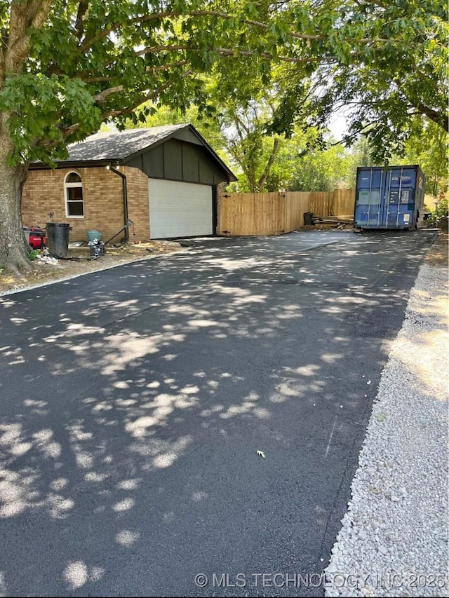 23422 E 79th St S, Broken Arrow, OK 74014 - view of home's exterior featuring driveway, a garage, brick siding, and an outbuilding