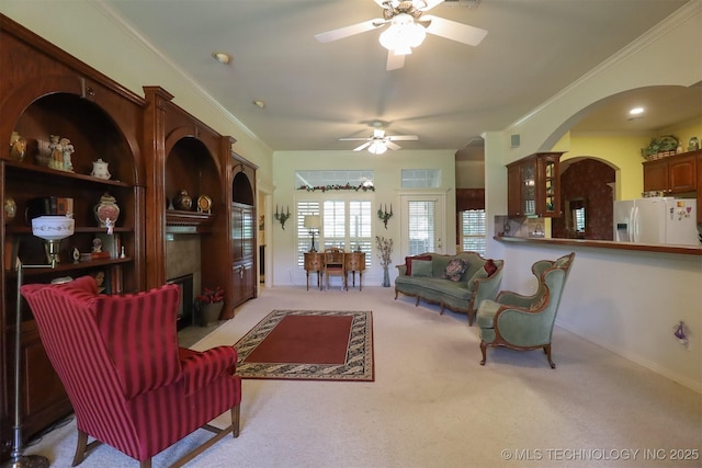 12310 S Mesa Rd, Sapulpa, OK 74066 - carpeted living area with a ceiling fan, a fireplace with flush hearth, arched walkways, and ornamental molding