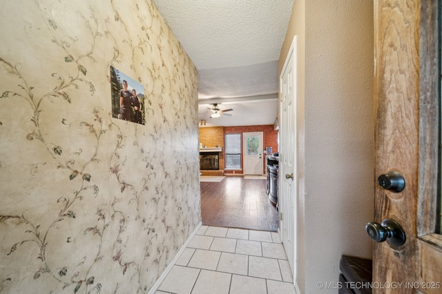 8102 N 121st E Ave, Owasso, OK 74055 - hallway featuring a textured ceiling, light tile patterned floors, and a textured wall