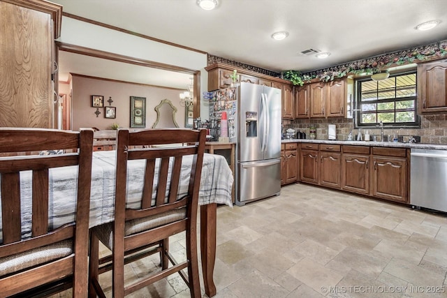 4152 W Oak St, Skiatook, OK 74070 - kitchen featuring appliances with stainless steel finishes, light stone finish floors, tasteful backsplash, light countertops, and a chandelier