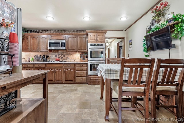 4152 W Oak St, Skiatook, OK 74070 - kitchen featuring appliances with stainless steel finishes, light stone finish flooring, tasteful backsplash, and light countertops