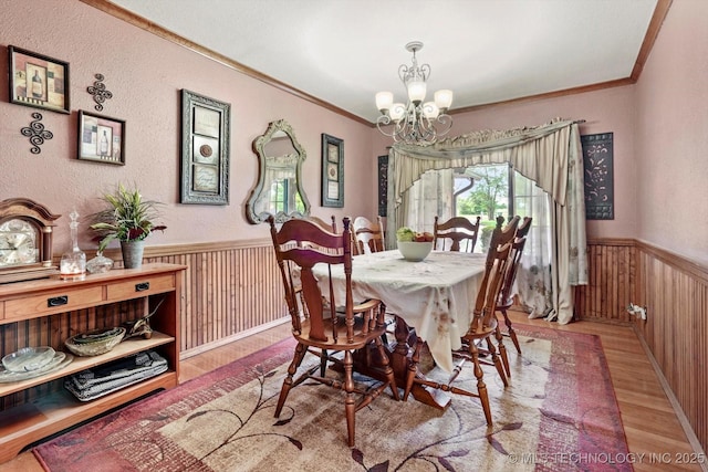 4152 W Oak St, Skiatook, OK 74070 - dining room featuring wood finished floors, wainscoting, a chandelier, crown molding, and wood walls
