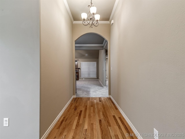 4667 E 144th Pl S, Bixby, OK 74008 - hall featuring arched walkways, ornamental molding, a chandelier, and light wood-style flooring
