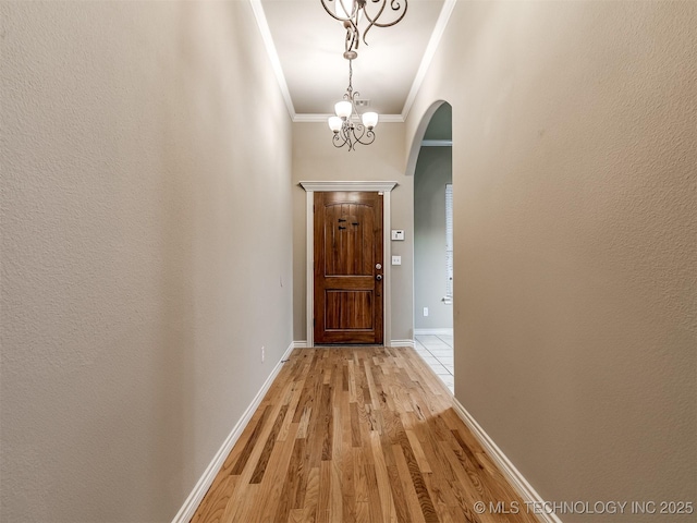 4667 E 144th Pl S, Bixby, OK 74008 - doorway with arched walkways, ornamental molding, light wood-style flooring, and a chandelier