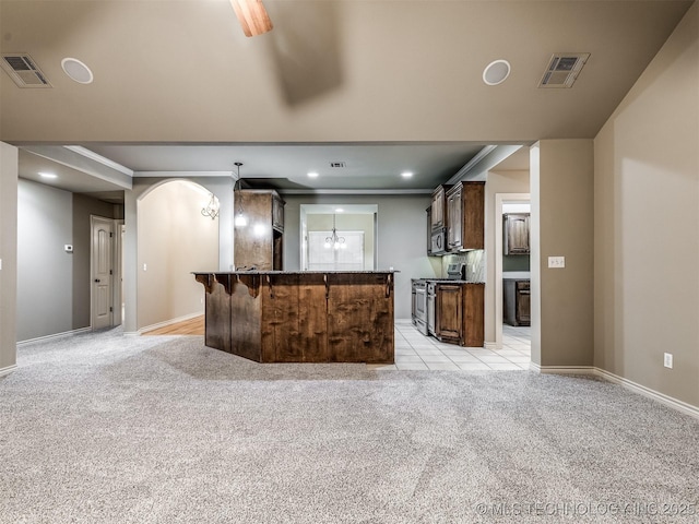 4667 E 144th Pl S, Bixby, OK 74008 - kitchen featuring stainless steel appliances, light colored carpet, arched walkways, recessed lighting, and dark brown cabinetry