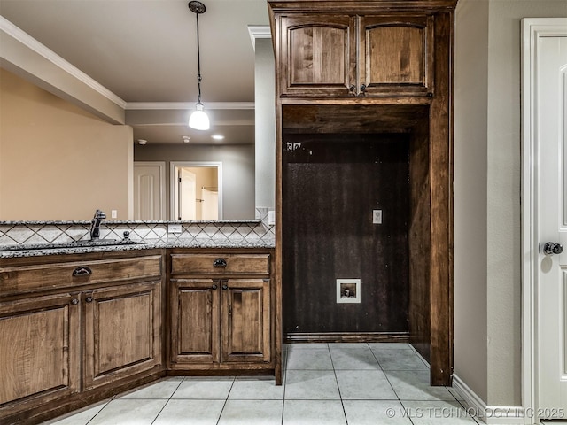 4667 E 144th Pl S, Bixby, OK 74008 - kitchen with light tile patterned flooring, ornamental molding, decorative light fixtures, dark brown cabinets, and stone counters
