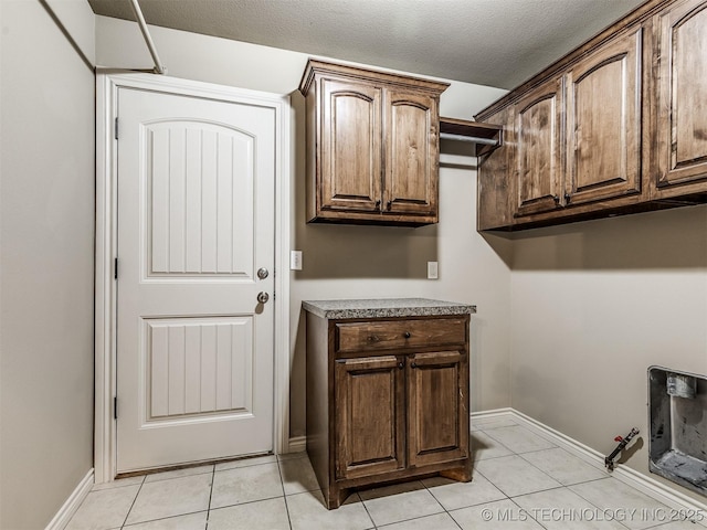 4667 E 144th Pl S, Bixby, OK 74008 - washroom with hookup for a gas dryer, cabinet space, light tile patterned floors, and a textured ceiling