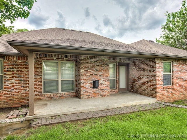 4667 E 144th Pl S, Bixby, OK 74008 - rear view of house featuring brick siding, a patio, and roof with shingles