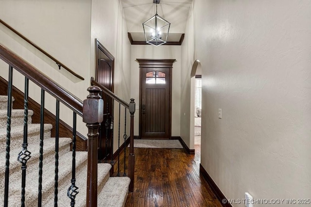 2015 W 109th St, Jenks, OK 74037 - foyer featuring arched walkways, a chandelier, dark wood-type flooring, stairs, and a towering ceiling