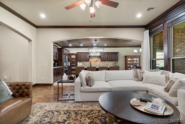 2015 W 109th St, Jenks, OK 74037 - living area featuring arched walkways, a ceiling fan, crown molding, dark wood finished floors, and recessed lighting