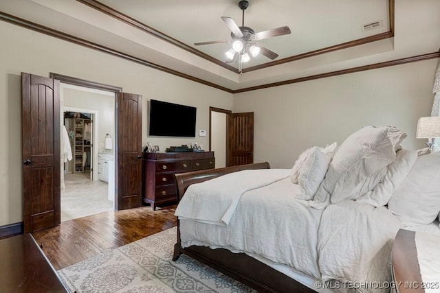 2015 W 109th St, Jenks, OK 74037 - bedroom featuring a tray ceiling, wood finished floors, crown molding, a ceiling fan, and a spacious closet
