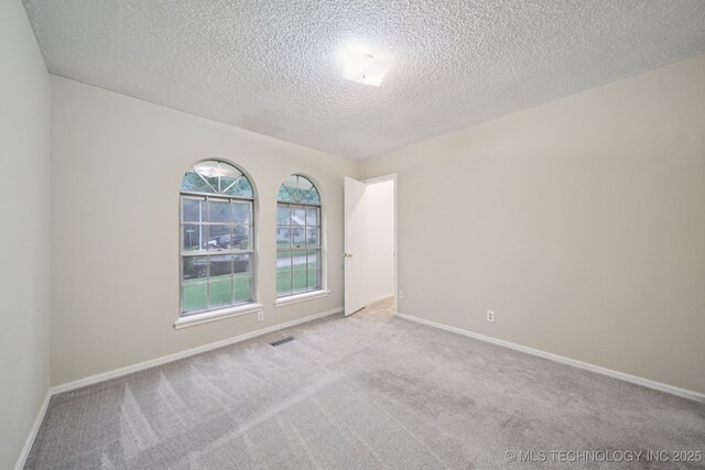 3002 E 80th Pl, Tulsa, OK 74136 - carpeted spare room with a textured ceiling and baseboards