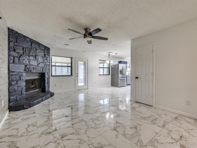 314 N Tallchief St, Skiatook, OK 74070 - unfurnished living room with a ceiling fan, a stone fireplace, a textured ceiling, and light marble finish flooring