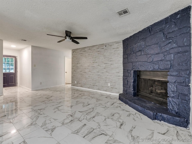 314 N Tallchief St, Skiatook, OK 74070 - unfurnished living room with a ceiling fan, a stone fireplace, marble finish flooring, and a textured ceiling