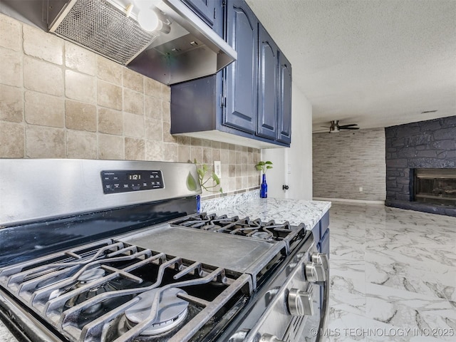 314 N Tallchief St, Skiatook, OK 74070 - kitchen with stainless steel range with gas stovetop, exhaust hood, blue cabinetry, light countertops, and a fireplace