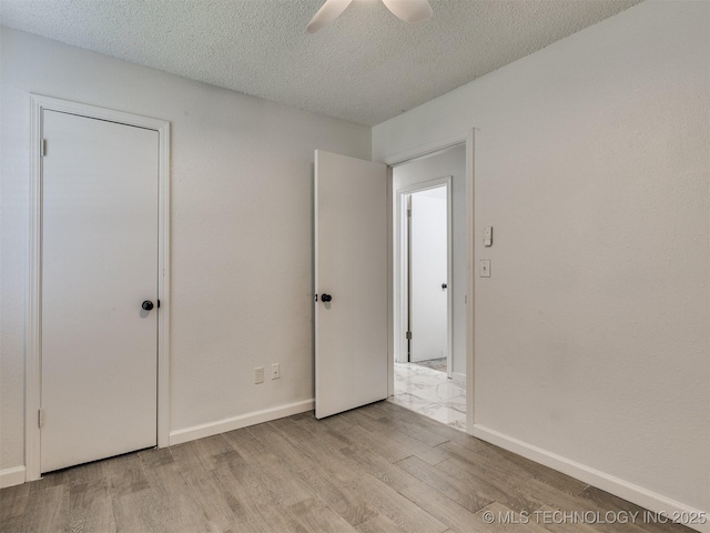 314 N Tallchief St, Skiatook, OK 74070 - unfurnished bedroom featuring wood finished floors, a textured ceiling, and a ceiling fan