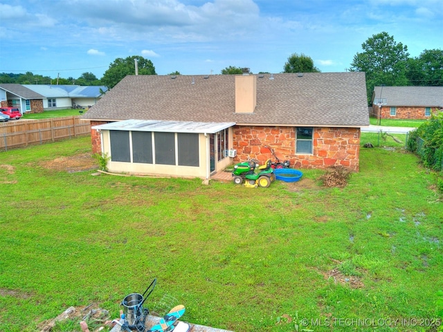 314 N Tallchief St, Skiatook, OK 74070 - rear view of house featuring a sunroom, a fenced backyard, a chimney, roof with shingles, and stone siding
