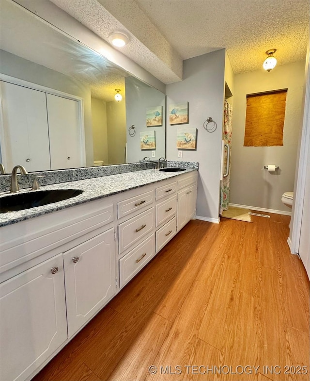 115842 S 4196, Checotah, OK 74426 - bathroom with double vanity, wood finished floors, and a textured ceiling
