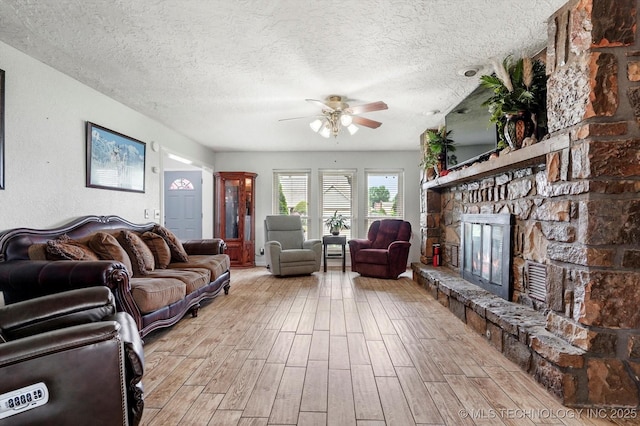 2605 W Atlanta Ct, Broken Arrow, OK 74012 - living area with a ceiling fan, light wood-style floors, a fireplace, and a textured ceiling