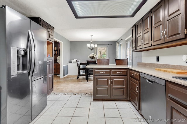 2605 W Atlanta Ct, Broken Arrow, OK 74012 - kitchen with appliances with stainless steel finishes, a chandelier, light countertops, light tile patterned flooring, and dark brown cabinetry