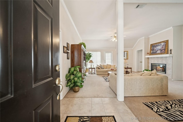 1101 S Yellowood Ave, Broken Arrow, OK 74012 - foyer entrance with light carpet, crown molding, light tile patterned flooring, ceiling fan, and a tile fireplace