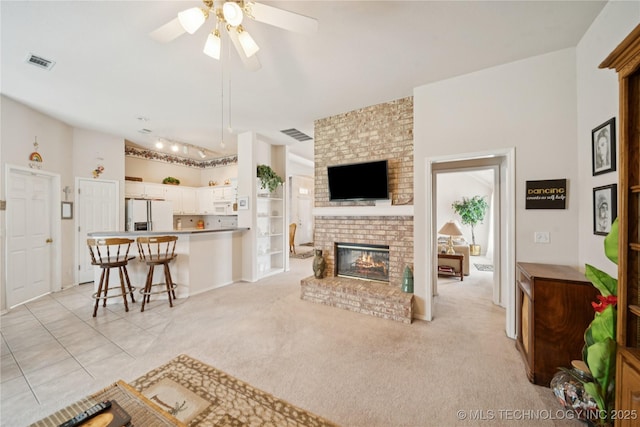 1101 S Yellowood Ave, Broken Arrow, OK 74012 - living area with ceiling fan, a brick fireplace, rail lighting, and light carpet