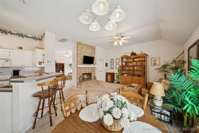 1101 S Yellowood Ave, Broken Arrow, OK 74012 - dining area with a ceiling fan, lofted ceiling, and a fireplace