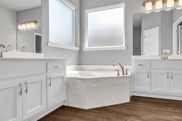2012 W Huntsville Pl, Broken Arrow, OK 74011 - bathroom with two vanities, a garden tub, and wood finished floors