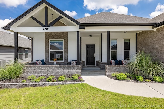 2012 W Huntsville Pl, Broken Arrow, OK 74011 - view of exterior entry with a porch, brick siding, a yard, and a shingled roof